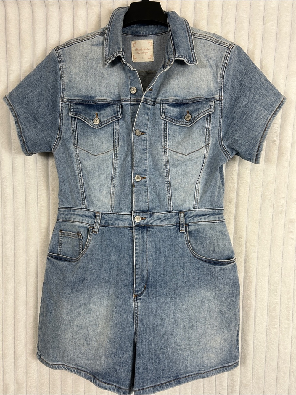 Altar'd State denim romper features a light wash finish and a button-up front L
